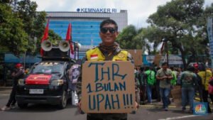 foto ojol memegang poster saat unjuk rasa