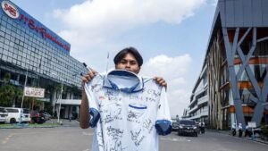 Seorang Karyawan Sritex menunjukkan Baju Seragamnya sebagai ungkapan kesedihan saat Pabrik tersebut gulung tikar (foto : Antara)
