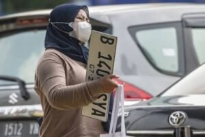 Warga mengurus balik nama kendaraan bermotor di kantor Samsat. Sejak Januari 2025, bea balik nama kendaraan bekas resmi digratiskan, namun pemilik tetap wajib membayar pajak dan biaya administrasi.(Istimewa)