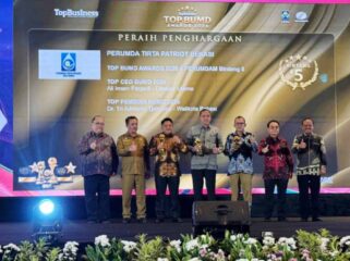 Direktur Perumda Tirta Patriot, Ali Imam Faryadi, saat menerima penghargaan di acara TOP BUMD 2026 bersama Wali Kota Bekasi