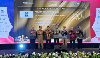 Direktur Perumda Tirta Patriot, Ali Imam Faryadi, saat menerima penghargaan di acara TOP BUMD 2026 bersama Wali Kota Bekasi
