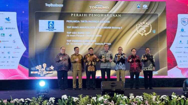 Direktur Perumda Tirta Patriot, Ali Imam Faryadi, saat menerima penghargaan di acara TOP BUMD 2026 bersama Wali Kota Bekasi