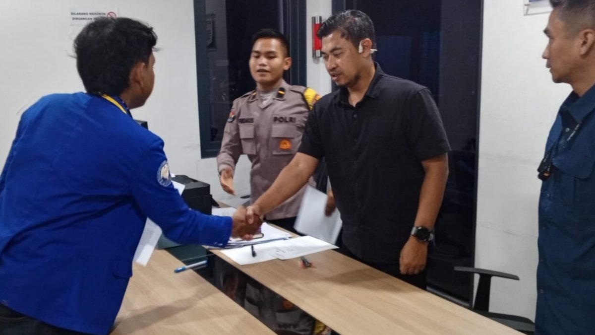 Perwakilan pengurus AKAMSI melakukan penyerahan dokumen laporan dan berjabat tangan dengan petugas penerima laporan sebagai simbol pengaduan resmi.